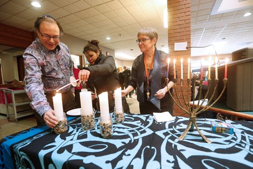JOHN WOODS / WINNIPEG FREE PRESS
Rabbi Alan Green (L) of Shaarey Zedek Synagogue and Lynda Trono, (R) Community Minister at West Broadway Community Ministry, are joined by Jermaine Scatch to light a menorah and advent candles at Crossways in Common Monday, December 25, 2017. Shaarey Zedek Synagogue joined West Broadway Community Ministry to serve over 100 people at its annual Christmas Lunch.