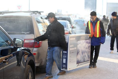 RUTH BONNEVILLE / WINNIPEG FREE PRESS

Fredie Natividad gets help from Best Buy employee to load up a big screen TV into his van in the cold outside Best Buy at Polo Park Tuesday.  They were just a few of the hundreds of bargain hunters who braved the cold for the annual boxing day sales.



Dec 26, 2017
