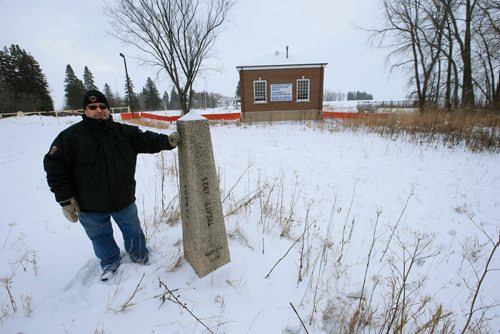 WAYNE GLOWACKI / WINNIPEG FREE PRESS 

Doug Johnston, Councillor, Municipality of Emerson-Franklin stands on the Canadian side of  the international border marker near Emerson, Mb. where many border crossers have entered Canada. Behind him is the former US Customs And Border Protection - Port Of Entry in Noyes, Minnesota.     Dylan Robertson story   Dec. 28  2017