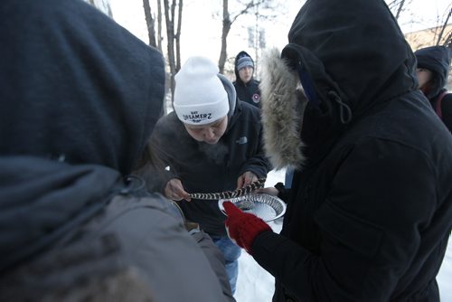 PHIL HOSSACK / WINNIPEG FREE PRESS - Brittany Murdoch lights and blows on a smudge to offer her brother Jeremy Thursday afternoon in front of the house where his was found dead of an overdose Christas Eve. See story. - December 28, 2017