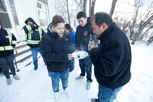 PHIL HOSSACK / WINNIPEG FREE PRESS - Larry Hobson takes a smudge offered by his daughter Brittany  Murdoch Thursday afternoon in front of the house where his son Jeremy was found dead of an overdose Christas Eve. Larry's other son Dillan stands left of his father. See story.  -  December 28, 2017