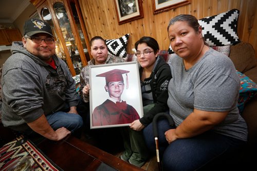JOHN WOODS / WINNIPEG FREE PRESS
From left Vance, April, Tracy and Nancy Flett hold a photo of her son Joseph "Beeper" Spence in their home Tuesday, January 9, 2018. Spence was shot by a gang member in a case of mistaken identity.