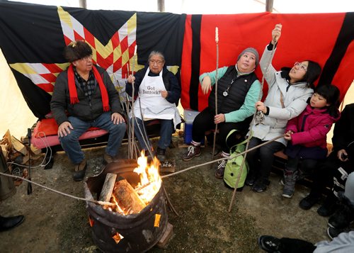 TREVOR HAGAN / WINNIPEG FREE PRESS
From left, Clarence, Barbara and Melissa Nepinak demonstrating how to make bannock with Uyung Woon and Irene Cha, 5, at The Forks, Sunday, January 21, 2018.