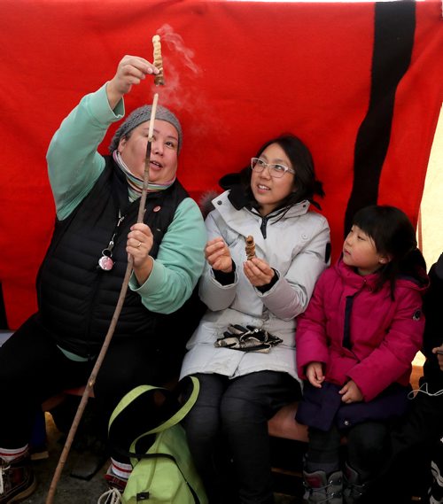 TREVOR HAGAN / WINNIPEG FREE PRESS
Melissa Nepinak demonstrates how to make bannock with Uyung Woon and Irene Cha, 5, at The Forks, Sunday, January 21, 2018.