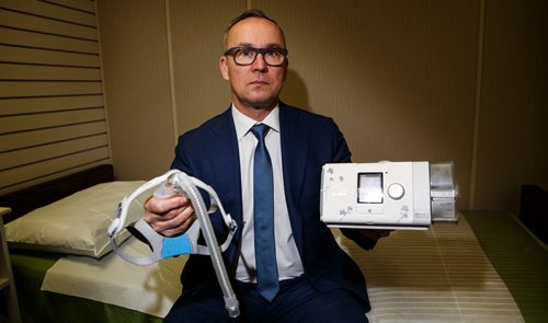 MIKE DEAL / WINNIPEG FREE PRESS
Ken Dufault, vice president and general manager at Medigas, holds a CPAP therapy machine and mask in one of the assessment rooms at their office on McPhillips Street. The family owned local company is a supplier of CPAP machines in Manitoba.
180123 - Tuesday, January 23, 2018.