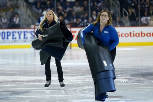 JOHN WOODS / WINNIPEG FREE PRESS
Jen Derksen, member of the Ice Crew, gathers mats after the puck drop prior to first period NHL action between the Winnipeg Jets vs Arizona Coyotes in Winnipeg on Tuesday, February 6, 2018.