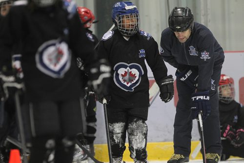 RUTH BONNEVILLE / WINNIPEG FREE 

49.8 TNYF feature.  Grade 4/5 students from Crestview School learn to play hockey on ice with Murray Cobb, Director, Winnipeg Jets Hockey Academy and volunteers at Iceplex Tuesday.  Story on the 12th year, the Winnipeg Jets Hockey Academy's  play-based program that is designed to increase school attendance and high school graduation rates, and instill life skills through the game of hockey. 
  Photo of Murray Cobb, Director, Winnipeg Jets Hockey Academy working with student, Precious, on ice.  

See Randy Turner story.
Feb 09/18