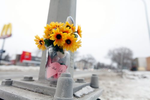 PHIL HOSSACK / WINNIPEG FREE PRESS - At a crosswalk a small bouquet serves as memorial at the scene of a young boy's death at Varennes ave and St Annes Rd Tuesday afternoon. See story. February 13, 2018