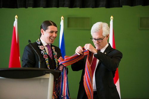 MIKAELA MACKENZIE / WINNIPEG FREE PRESS
Robert-Falcon Ouellette presents Jim Carr with a Metis sash after Carr announced funding for initiatives to reduce reliance on diesel fuel in rural and remote communities in Winnipeg, Manitoba on Friday, Feb. 16, 2018. 
180216 - Friday, February 16, 2018.