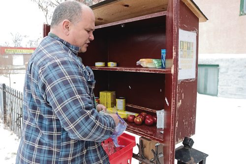 Canstar Community News Feb. 14, 2018 - Kelly Hughes fills a community cupboard with food. He volunteers with the Fountain Street Community Cupboard. (LIGIA BRAIDOTTI/CANSTAR/TIMES)