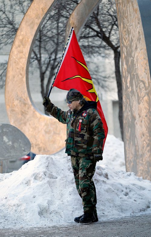 PHIL HOSSACK / WINNIPEG FREE PRESS -A lone warrior waves the AIM flag outside the Winnipeg Courthouse Thursday after Raymond Cormier was found not guilty in the murder of Tina Fontaine. See story. - February 22, 2018