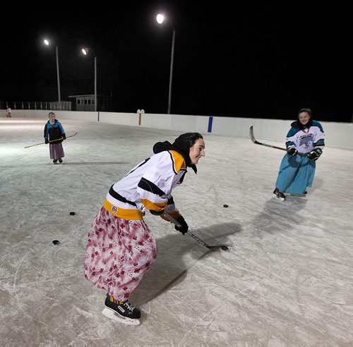 PHIL HOSSACK / WINNIPEG FREE PRESS - Tessa Waldner 10, watches as sisters Judith (centre) and Tirzah Maendel work their wrist shots on the Baker Colony ice rink. -See Melissa Martin's story.  - February 23, 2018