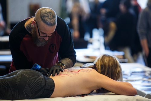 MIKE DEAL / WINNIPEG FREE PRESS
Gayle Buzzi gets a tattoo by Steve Morin during The Winnipeg Tattoo Show at the convention centre Saturday.
180224 - Saturday, February 24, 2018.