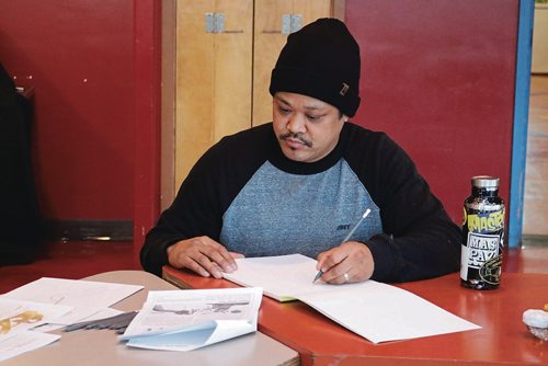 Canstar Community News Feb. 20 - Pat Lazo, Graffiti Art Programming director, draws a sketch inspired by the existing painting on the exterior of the Indigenous Family Centre by Jackson Beardy. (LIGIA BRAIDOTTI/CANSTAR/TIMES)