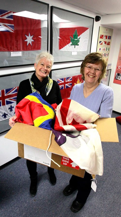 BORIS MINKEVICH / WINNIPEG FREE PRESS
Argyle Museum Settlers, Rails & Trails Inc flag museum in the Argyle Community Centre. From left, Joan Grandmont and Carol Morgan with some flags donated . BILL REDEKOP STORY Feb. 28, 2018