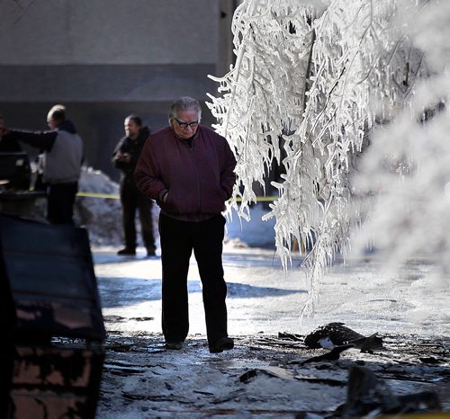 PHIL HOSSACK / WINNIPEG FREE PRESS - An unidentified man walks through the aftermath of an overnight fire at "No Name Auto", see story.   - February 28, 2018