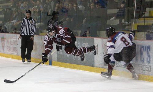 PHIL HOSSACK / WINNIPEG FREE PRESS -St Paul Crusader # 19 Ethan Lewis goes airborne after failing to evade Sturgeon Heights Huskie #8 Jacob Cressman in the first period of a hard hitting High School playoff game Wednesday. See Mike Sawatzky's story.   - February 28, 2018