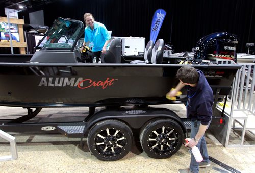 BORIS MINKEVICH / WINNIPEG FREE PRESS
The Mid-Canada Boat Show (also referred to as the Winnipeg Boat Show) started yesterday and goes on through the weekend at the RBC Convention Centre. From left, Guertin Equipment workers Candace Daniel and Brennan Tait polish up the boats in their area. This one is a limited edition Alumacraft 205 shadow series. March 2, 2018