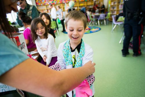 MIKAELA MACKENZIE / WINNIPEG FREE PRESS
Wyatt Kind, six, tries on rubber gloves before beginning a pretend "surgery" with Dr. Nafisa Dharamsi at an activity where women in various fields of work came in and talked to children on Women's Day at Weston School in Winnipeg, Manitoba on Thursday, March 8, 2018.
180308 - Thursday, March 08, 2018.