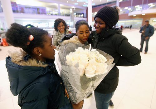 PHIL HOSSACK / WINNIPEG FREE PRESS -  Left to Right, Nine year old Rachel Bisimwa holds a bouquet of roses as her sister Alice hugs their long lost sister Naomi (16) Thursday evening. Their mother Maria 2nd from left smiles as her children are reunited.  Carol Sanders story. - March 8, 2018
