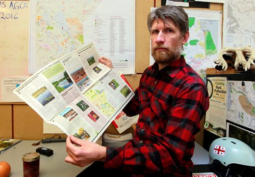 BORIS MINKEVICH / WINNIPEG FREE PRESS
Green Page - For story about the effects of climate change, specifically the effects on the eco-system here in Manitoba. Eric Reder from Wilderness Committee poses for a photo in his office with a publication they put out on the topic. He is a climate change expert with the Western Canada Wilderness Committee.  March 13, 2018
