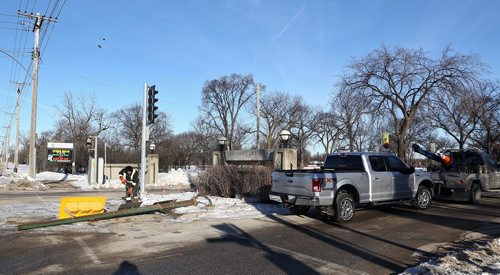 MIKE DEAL / WINNIPEG FREE PRESS
A city traffic maintenance worker installs a new traffic light after a pickup truck crashed into it in front of the Assiniboine Park sign on Corydon and Shaftesbury this morning. 
180315 - Thursday, March 15, 2018.