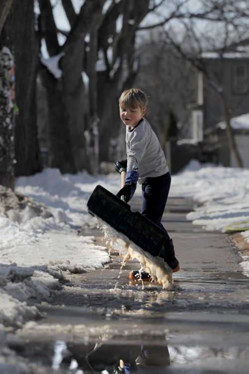 RUTH BONNEVILLE  /  WINNIPEG FREE PRESS

Twelve-year-old Liam Chua pushes water away from the front of his house with his shovel i while playing with his sister and dad in the warm afternoon sunshine Saturday on Westminster.   

March 17, 2018