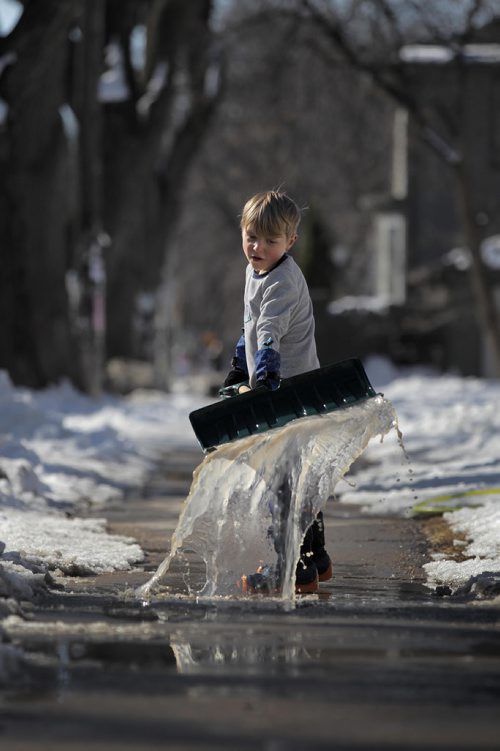 RUTH BONNEVILLE  /  WINNIPEG FREE PRESS

Twelve-year-old Liam Chua pushes water away from the front of his house with his shovel i while playing with his sister and dad in the warm afternoon sunshine Saturday on Westminster.   

March 17, 2018