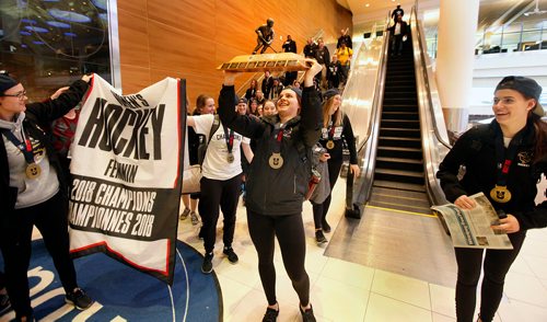 PHIL HOSSACK / WINNIPEG FREE PRESS - University of Manitoba Bisons' Erica Rieder hiosts the trophy over her head as she and the rest of her hockey team arrived back in Winnipeg after winning their first ever national championship. See Alex Paul's story.  March 19, 2018