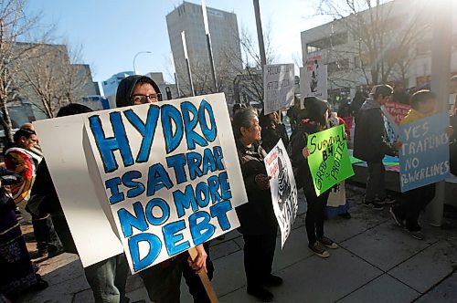 PHIL HOSSACK / WINNIPEG FREE PRESS - A protestor, one of about a hundred, peers over his placard Thursday afternoon as a protest march gathered at Manitoba Hydro's Portage ave offices and prepared to walk to Thunderbird House. See Alex Paul's story.- March 22, 2018