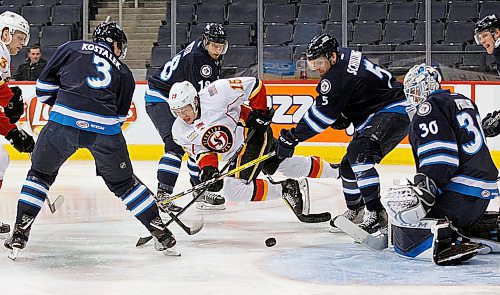 PHIL HOSSACK / WINNIPEG FREE PRESS - Stockton Heat #15 Spencer Foo takes a header in front of the Moose netminder #30 Jamie Phillips and surrounded by Mosse defenders (L-R) #3 Jan Kostalek, #18 Brody Sutter and #5 Cameron Sgarbosse at Bell MTS Place. - March 22, 2018