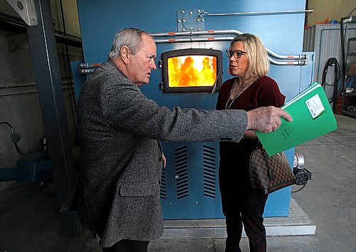 PHIL HOSSACK/Winnipeg Free Press - Minister Rochelle Squires and Raymond Dueck in front of the combustion chamber, as he explains the workings of a large biomass heating unit Tuesday afternoon on the Vermillion Hutterite Colony near Sanford Mb. The community uses Biomass combustion to heat about 100,000 sq ft of barns and outbuildings. Homes on the colony are heated with GeoThermal technology. (I believe Raymond is the original inventor of these particular Biomass units. See Bill Redekop story. March27, 2018