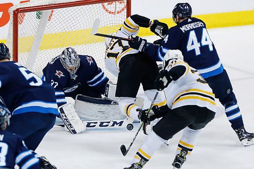 Winnipeg Jets goaltender Connor Hellebuyck (37) saves the shot by  Boston Bruins' Ryan Donato  (17) as Jets' Josh Morrissey (44) defends during first period NHL action in Winnipeg on Tuesday, March 27, 2018. THE CANADIAN PRESS/John Woods