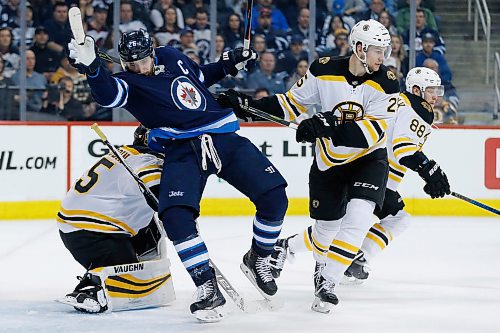 Winnipeg Jets' Blake Wheeler (26) gets pushed into Boston Bruins goaltender Anton Khudobin (35) by  Bruins' Brandon Carlo (25) defends during second period NHL action in Winnipeg on Tuesday, March 27, 2018. THE CANADIAN PRESS/John Woods