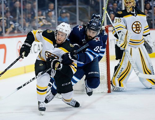 Winnipeg Jets' Mathieu Perreault (85) and  Boston Bruins'bb48\ fight for position during second period NHL action in Winnipeg on Tuesday, March 27, 2018. THE CANADIAN PRESS/John Woods