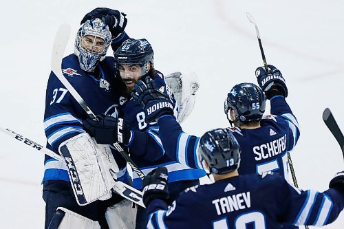 Winnipeg Jets goaltender Connor Hellebuyck (37), Mathieu Perreault (85), Brandon Tanev (13) and Mark Scheifele (55) celebrate defeating the  Boston Bruins in a shootout in NHL action in Winnipeg on Tuesday, March 27, 2018. THE CANADIAN PRESS/John Woods