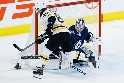 Winnipeg Jets goaltender Connor Hellebuyck (37) stops the shot by  Boston Bruins' David Pastrnak (88) during the shootout in NHL action in Winnipeg on Tuesday, March 27, 2018. THE CANADIAN PRESS/John Woods