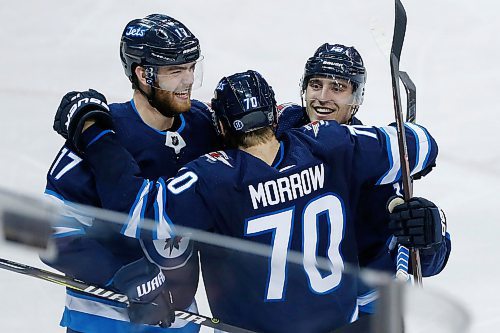 Winnipeg Jets' Adam Lowry (17), Joe Morrow (70) and¤Brandon Tanev (13) celebrate Tanev's hat-trick against  the Boston Bruins during third period NHL action in Winnipeg on Tuesday, March 27, 2018. THE CANADIAN PRESS/John Woods