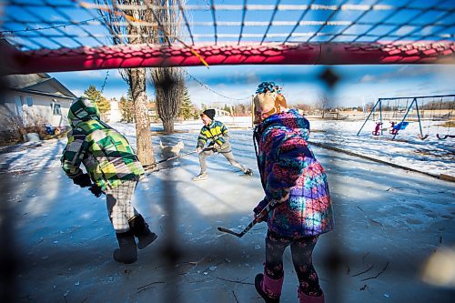 MIKAELA MACKENZIE / WINNIPEG FREE PRESS
Adam (left), Caleb, and Kyla Nobel play a game of hockey in their boots on their backyard rink in Transcona in Winnipeg on Wednesday, March 28, 2018.
Mikaela MacKenzie / Winnipeg Free Press 28, 2018.