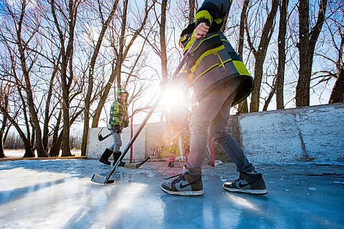 MIKAELA MACKENZIE / WINNIPEG FREE PRESS
Adam (left), Kyla, and Caleb Nobel play a game of hockey in their boots on their backyard rink in Transcona in Winnipeg on Wednesday, March 28, 2018.
Mikaela MacKenzie / Winnipeg Free Press 28, 2018.