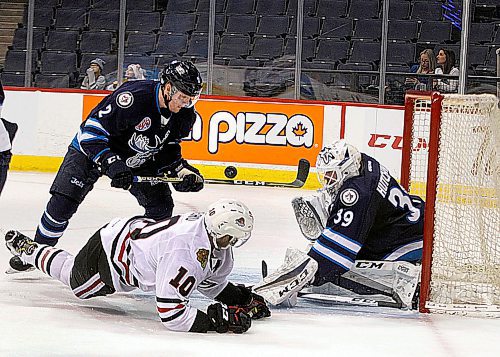 PHIL HOSSACK / WINNIPEG FREE PRESS - Rockford Icehog #10 Tanner Kero falls as he flips the puck up and off Manitoba Moose #2 Kirill Gotovets stick and into #39 Michael Hutchinson's net Wednesday evening at Bell MTS Place making the score 2-1 Icehogs.  - March 28, 2018