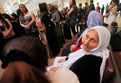 PHIL HOSSACK / WINNIPEG FREE PRESS - Overwhelmed by travel and welcome, Family matriarch Shireen Khudida (centre left) had to take a seat in the midst of the throngs of Yazidi's who came to Richardson International Airport Thursday to welcome the matriarch and the last of "Operation Ezra's" Yazidi families to Winnipeg and Canada. See Carol Sanders story. - March 29, 2018