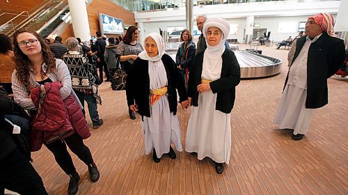 PHIL HOSSACK / WINNIPEG FREE PRESS - Holding hands, family matriarch Shireen Khudida (centre left) and her daughter Base Quave make their way through the throngs of Yazidi's who came to Richardson International Airport Thursday to welcome the matriarch and the last of "Operation Ezra's" Yazidi families to Winnipeg and Canada. See Carol Sanders story. - March 29, 2018