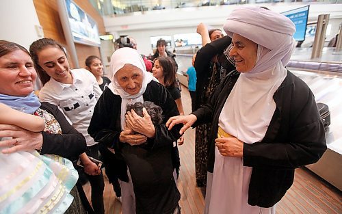 PHIL HOSSACK / WINNIPEG FREE PRESS - Overwhelmed by travel and welcome, Family matriarch Shireen Khudida embraces the throngs of Yazidi's who came to Richardson International Airport Thursday to welcome the matriarch and the last of "Operation Ezra's" Yazidi families to Winnipeg and Canada. Her daughter Base Qave right. See Carol Sanders story. - March 29, 2018