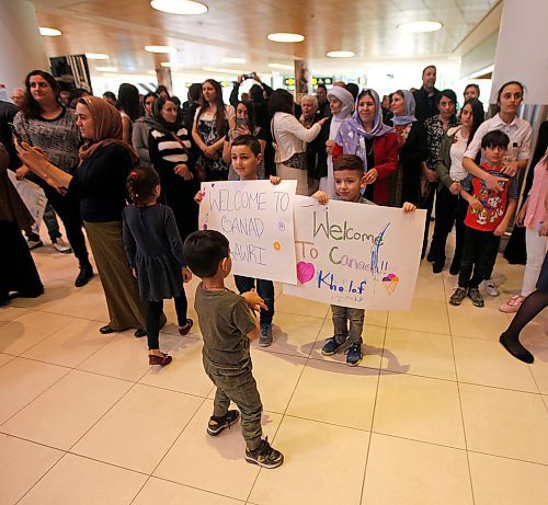 PHIL HOSSACK / WINNIPEG FREE PRESS - A young boy checks out the welcome signs brought by the throngs of Yazidi's who came to Richardson International Airport Thursday to welcome the matriarch and the last of "Operation Ezra's" Yazidi families to Winnipeg and Canada.  See Carol Sanders story. - March 29, 2018