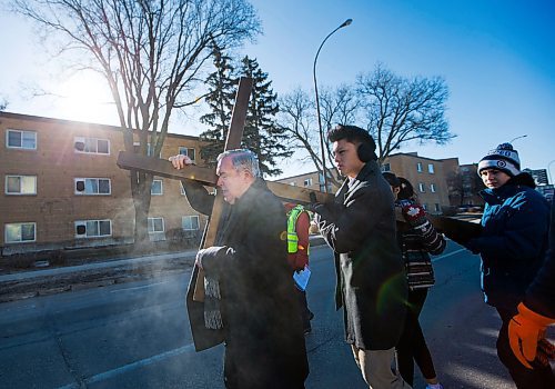 MIKAELA MACKENZIE / WINNIPEG FREE PRESS
Archbishop Richard Gagnon, helped by youth Miguel Olave and Noah Dannenberg, leads the Way of the Cross march down Pembina near the St. Vital Catholic Church in Winnipeg on Friday, March 30, 2018. 
Mikaela MacKenzie / Winnipeg Free Press 30, 2018.