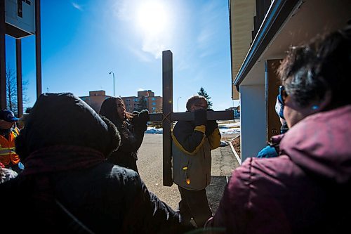 MIKAELA MACKENZIE / WINNIPEG FREE PRESS
Reverend Mark Tarrant, helped by youth Natalia Aguilar, brings the cross back into the St. Vital Catholic Church during the Way of the Cross march in Winnipeg on Friday, March 30, 2018. 
Mikaela MacKenzie / Winnipeg Free Press 30, 2018.