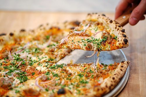 MIKE DEAL / WINNIPEG FREE PRESS
MUNCH MADNESS - Red Ember Pizza at The Forks. A Happy Pig pizza that has vodka sauce, red onion, house pork sausage, fontina and parsley on it. 
180405 - Thursday, April 5, 2018