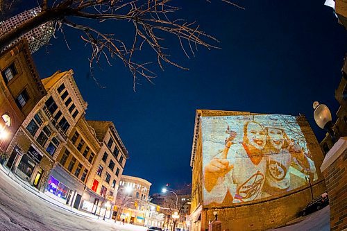 MIKAELA MACKENZIE / WINNIPEG FREE PRESS
Jets fan photos projected onto downtown buildings in Winnipeg on Thursday, April 5, 2018. 
Mikaela MacKenzie / Winnipeg Free Press 2018.