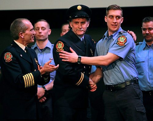 BORIS MINKEVICH / WINNIPEG FREE PRESS
FIRE GRAD 1801 - From left, WFPS Chief John Lane watches WFPS retired firefighter Gary Oakley present his son Ted with his badge #2501 at The Metropolitan Entertainment Centre this afternoon. 16 new recruits graduated today. April 13, 2018